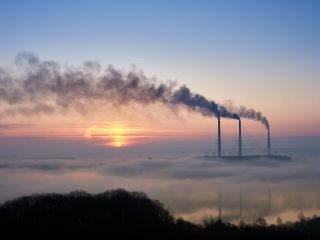 Stunning view of sky with bright rising sun at thermoelectric power plant. 